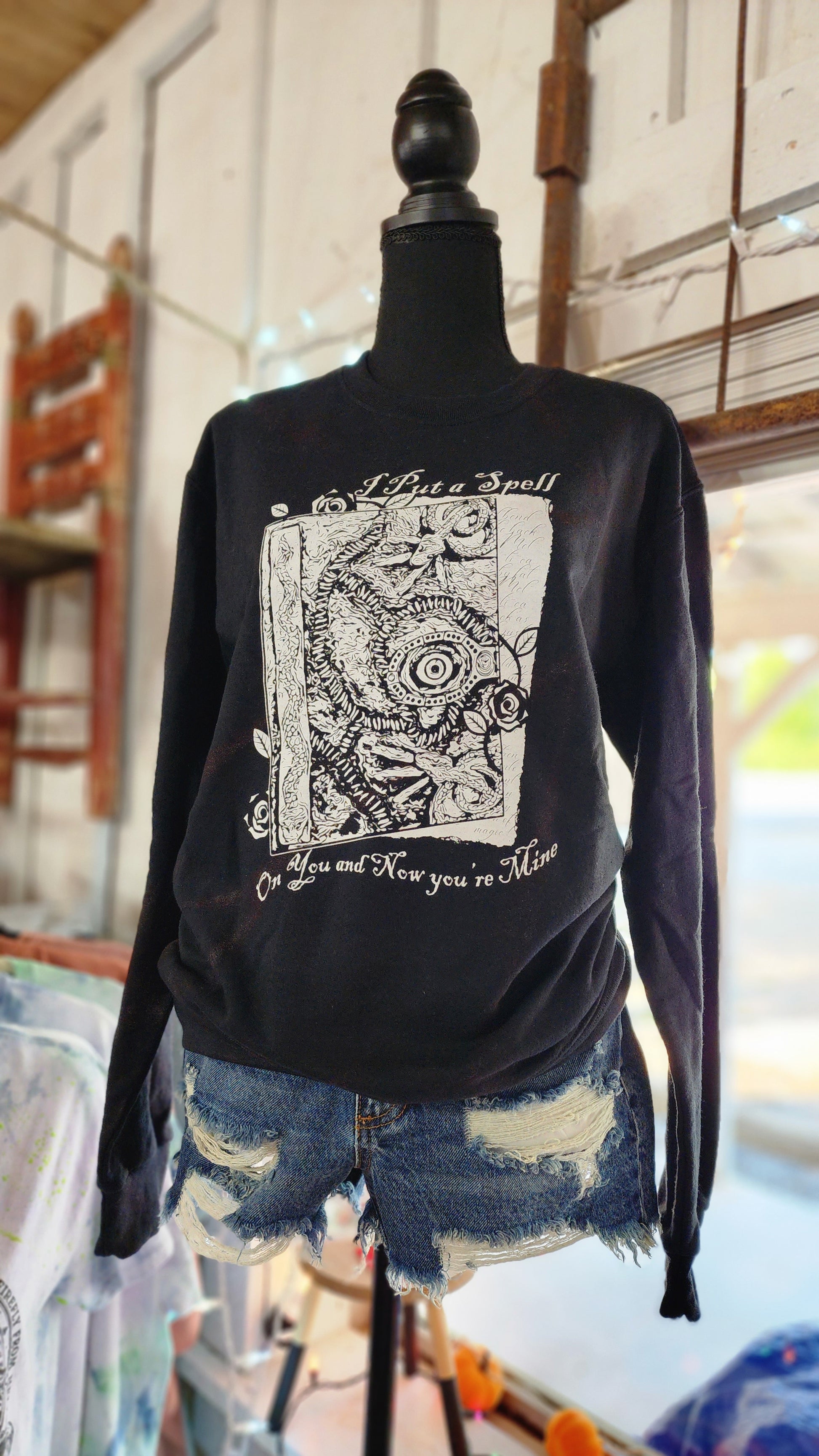 Black sweatshirt with image of Book (hocus pocus) in white.